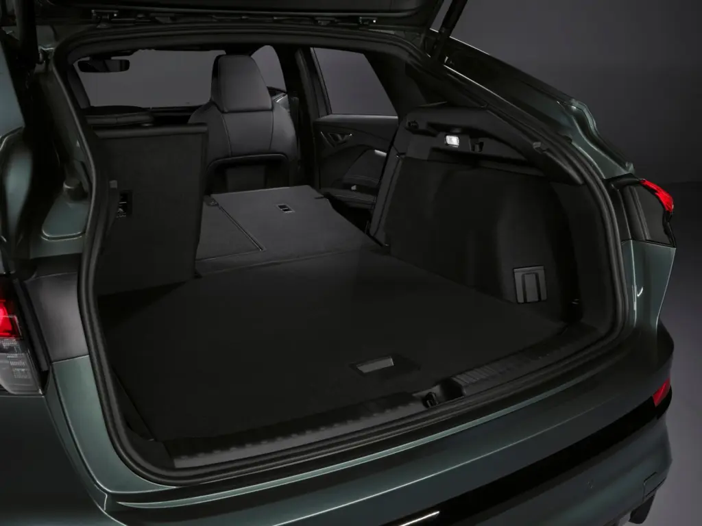 Otwarty bagażnik Audi Q4 e-tron z częściowo złożonymi siedzeniami, prezentujący dużą przestrzeń ładunkową.