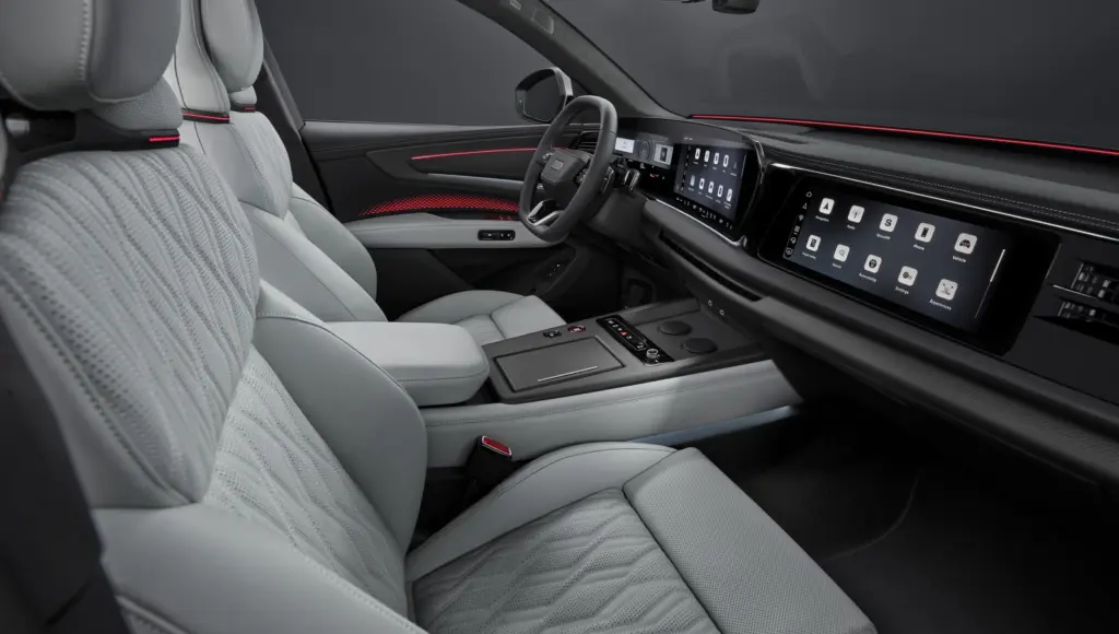 Luksusowe wnętrze Audi Q9 2026 z panoramicznymi ekranami OLED i białymi skórzanymi fotelami z przeszyciami.