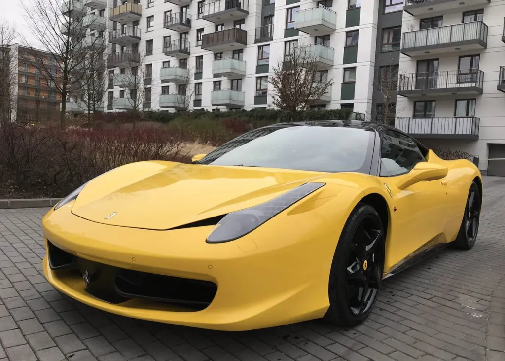 Żółte Ferrari 458 Italia zaparkowane pod blokiem – przykład luksusowego auta używanego do oszustw. Wyłudzenia odszkodowań komunikacyjnych