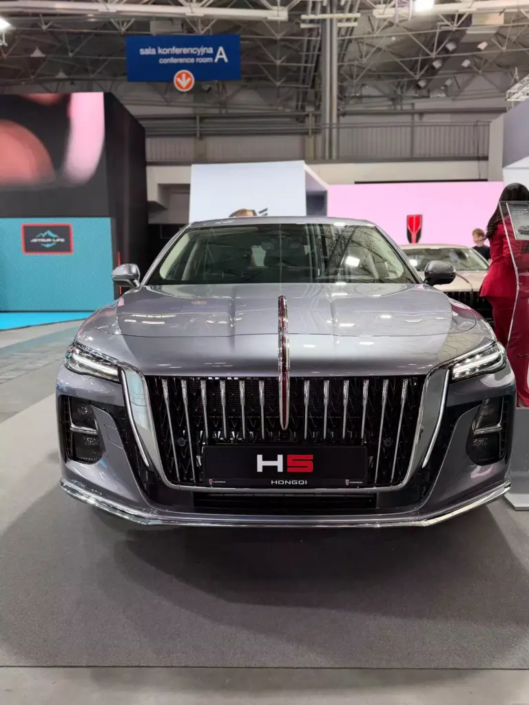 Przód luksusowego sedana Hongqi H5 z dużą chromowaną atrapą chłodnicy na wystawie motoryzacyjnej.