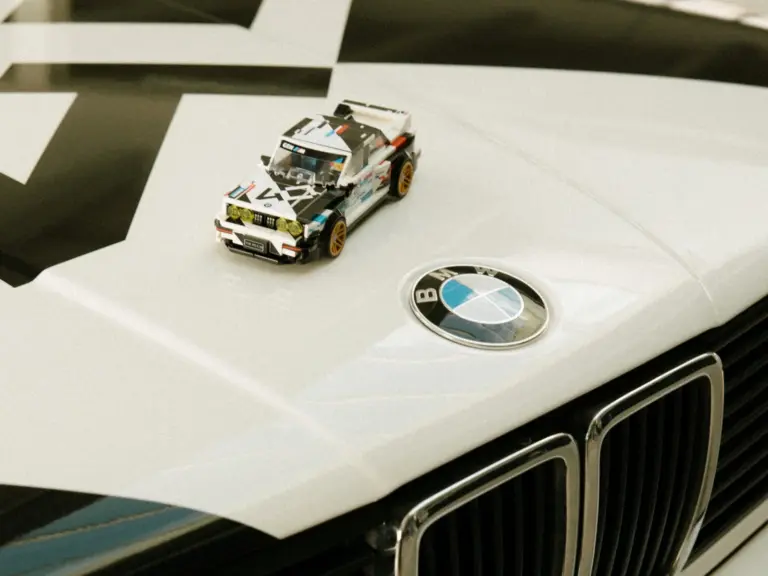LEGO BMW M3 E30 Speed Champions na masce klasycznego BMW M3 E30 obok logo BMW.
