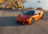 Lotus Emira 420 Sport. Cena dla Polski nadal nieznana Lotus Emira 420 Sport z przodu na drodze przy wybrzeżu