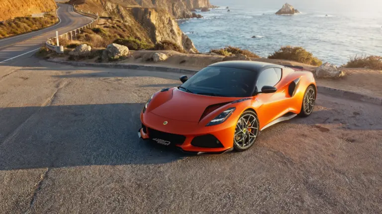 Lotus Emira 420 Sport z przodu na drodze przy wybrzeżu