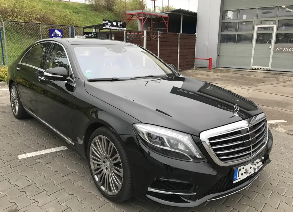 Czarny Mercedes Klasy S W222 na parkingu warsztatu motoryzacyjnego. Wyłudzenia odszkodowań komunikacyjnych