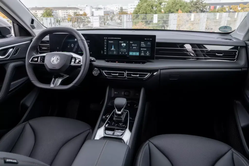 Wnętrze MG HS PHEV 2026 z podwójnym ekranem cyfrowym i czarną skórzaną tapicerką.