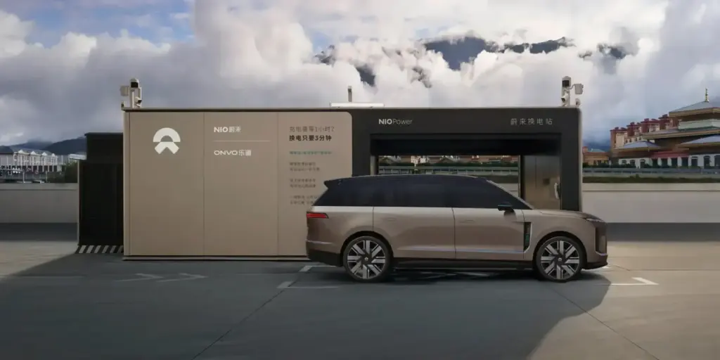 Złoty SUV NIO ES9 zaparkowany obok stacji wymiany baterii Power Swap Station 4.0.