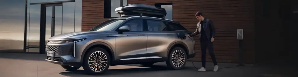 Omoda 9 Super Hybrid podczas ładowania baterii plug-in hybrid przy budynku.