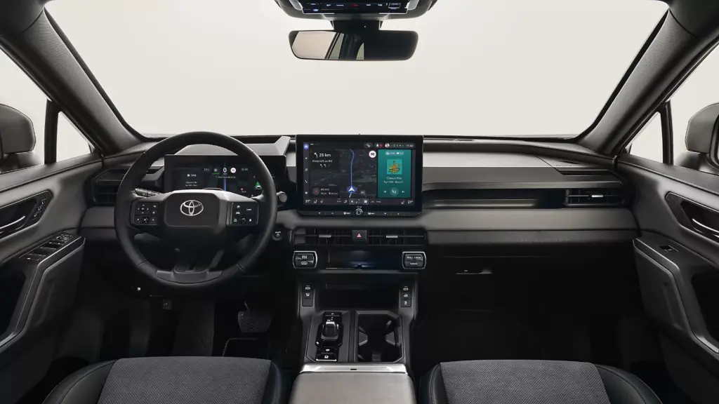 Wnętrze Toyoty RAV4 PHEV z centralnym ekranem dotykowym i fizycznymi przyciskami klimatyzacji.