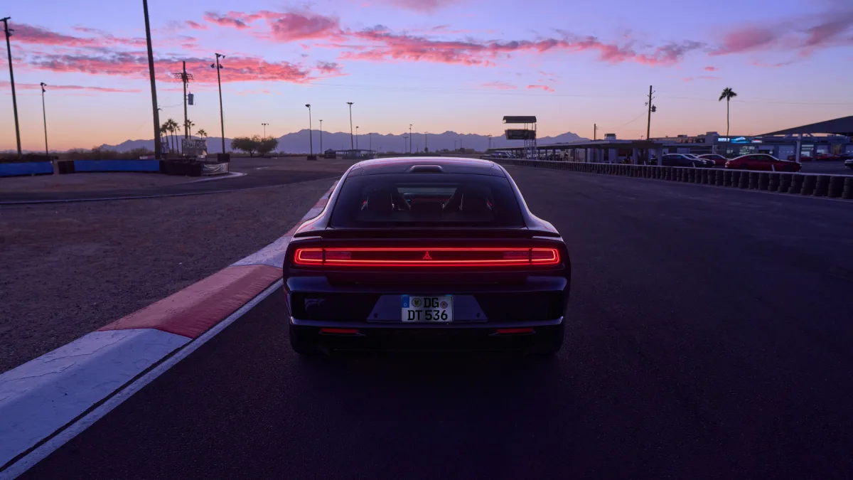 Tył Dodge Chargera Daytona 2026 z podświetloną listwą LED na torze o zmierzchu