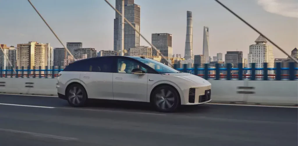 Li Auto i6 jadący przez miasto z panoramą Szanghaju w tle
