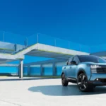 Nissan Kicks e-POWER 2026 z przodu jako hybrydowy crossover na tle nowoczesnej architektury