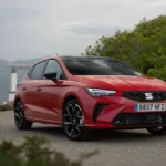 Czerwony SEAT Ibiza 2027 na drodze, widok z przodu, samochód miejski w polskim cenniku od 69 900 zł