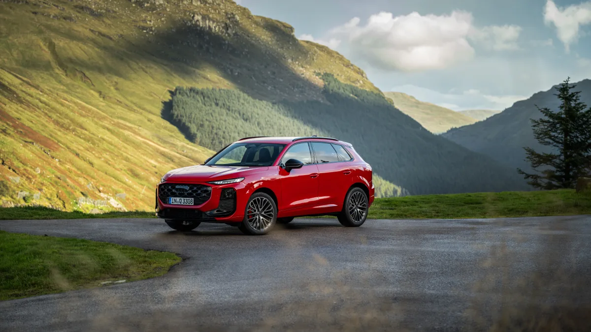 Czerwone Audi Q3 2027 na drodze w górskim krajobrazie