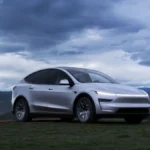 Srebrna Tesla Model Y L pokazana z przodu na tle gór