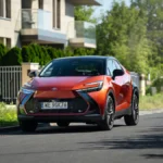 Toyota C-HR Hybrid z 2026 roku pokazana z przodu i z boku