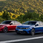 Nowe BMW serii 3 i niebieskie BMW i3 podczas jazdy górską drogą