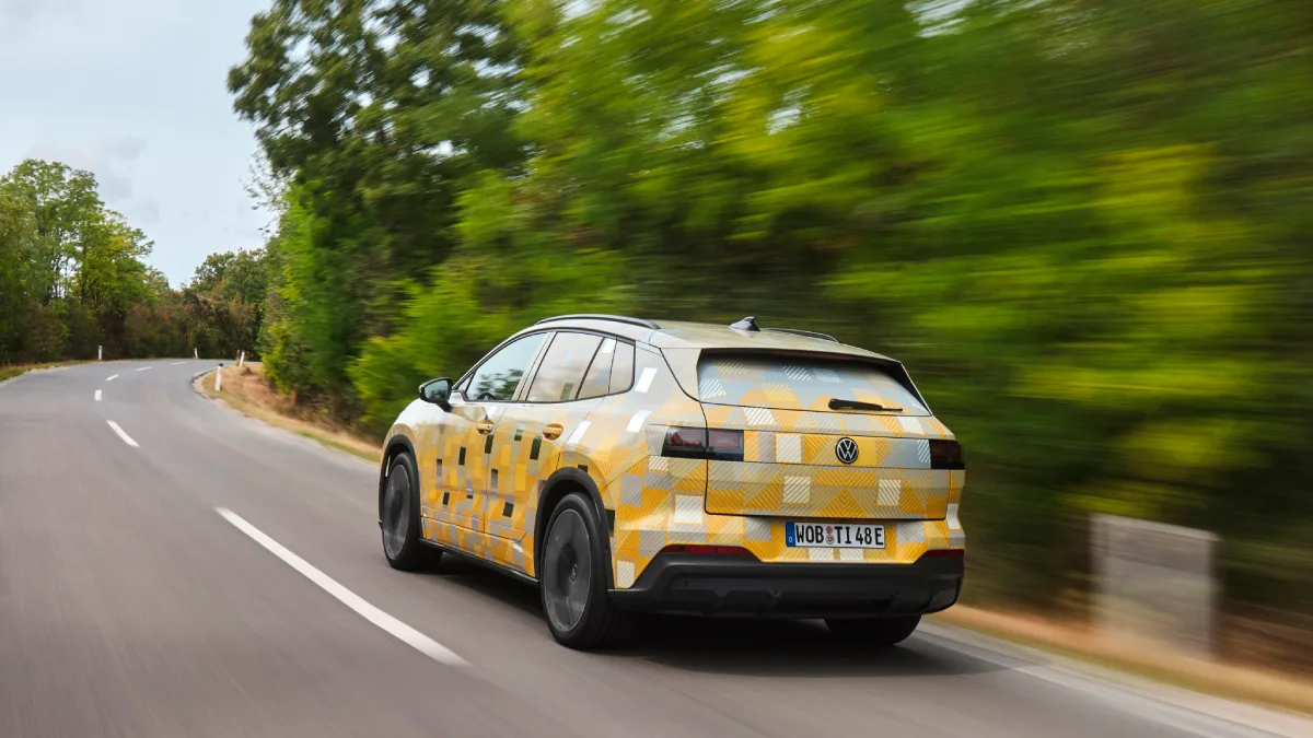 Tył zamaskowanego Volkswagena ID. Tiguana podczas jazdy krętą drogą