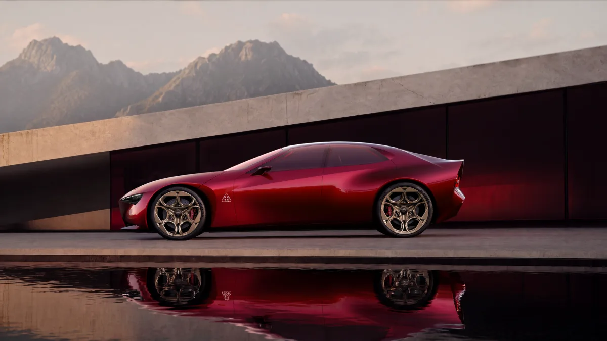 Alfa Romeo Cuorerosso widziana z boku, czerwone coupé o niskiej sylwetce, długiej masce i złotych kołach