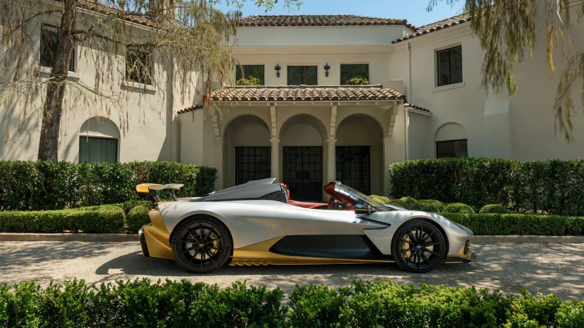 Aston Martin Valhalla Spider 2026 widziany z boku, srebrne nadwozie, złote elementy aerodynamiczne i otwarty kokpit