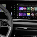 Spotify na ekranie systemu MMI w Audi, widok cyfrowego kokpitu z kierownicą, biblioteką muzyczną i odtwarzaczem