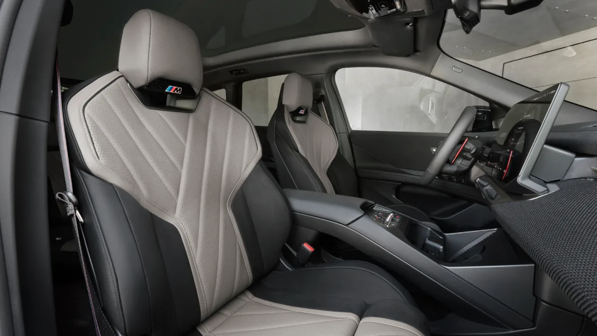 Przednie fotele BMW iX3 M60 xDrive z jasną tapicerką i logo M