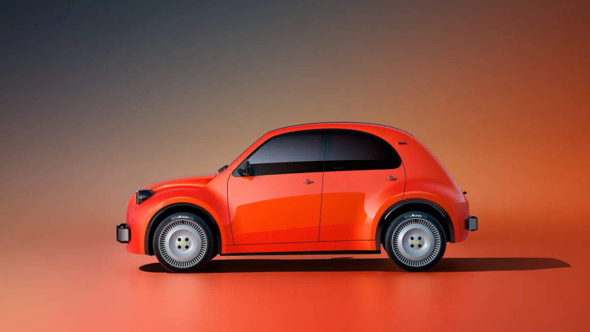 Pomarańczowy Citroën 2 CV Concept widziany z boku, z zaokrąglonym dachem i srebrnymi kołami
