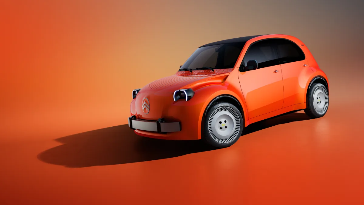Pomarańczowy Citroën 2 CV Concept pokazany z przodu i boku, z okrągłymi reflektorami i zaokrąglonym nadwoziem
