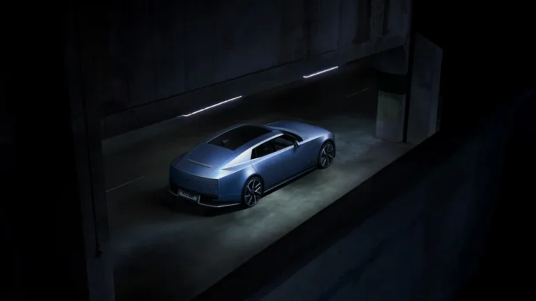 Niebieski Jaguar Type 01 widoczny od tyłu i z boku w betonowym przejeździe