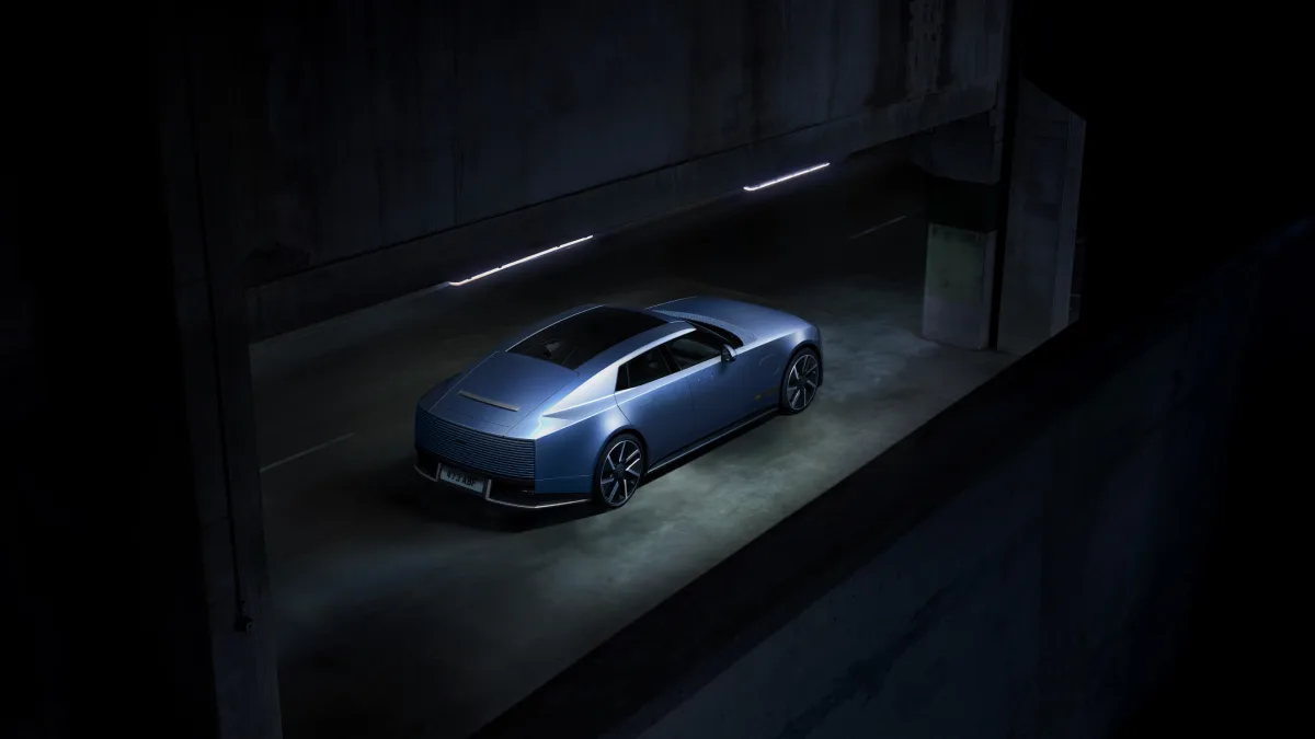 Niebieski Jaguar Type 01 widoczny od tyłu i z boku w betonowym przejeździe