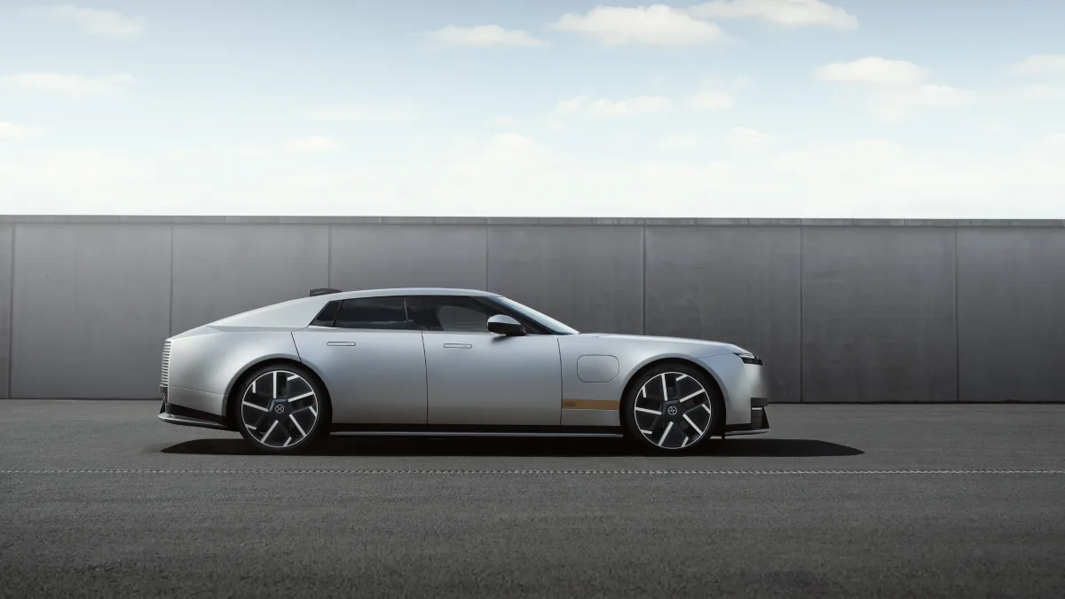 Srebrny Jaguar Type 01 z profilu na tle betonowej ściany