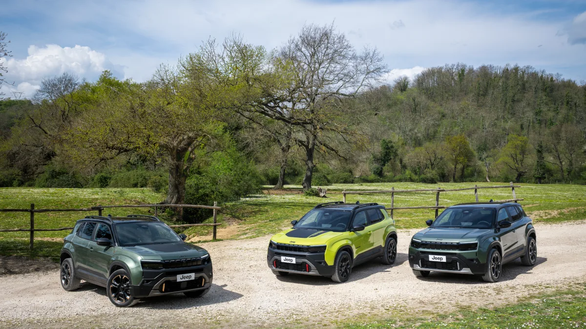 Trzy Jeepy Avenger 2026 w kolorach zielonym i limonkowym stojące na żwirowej drodze w otoczeniu drzew