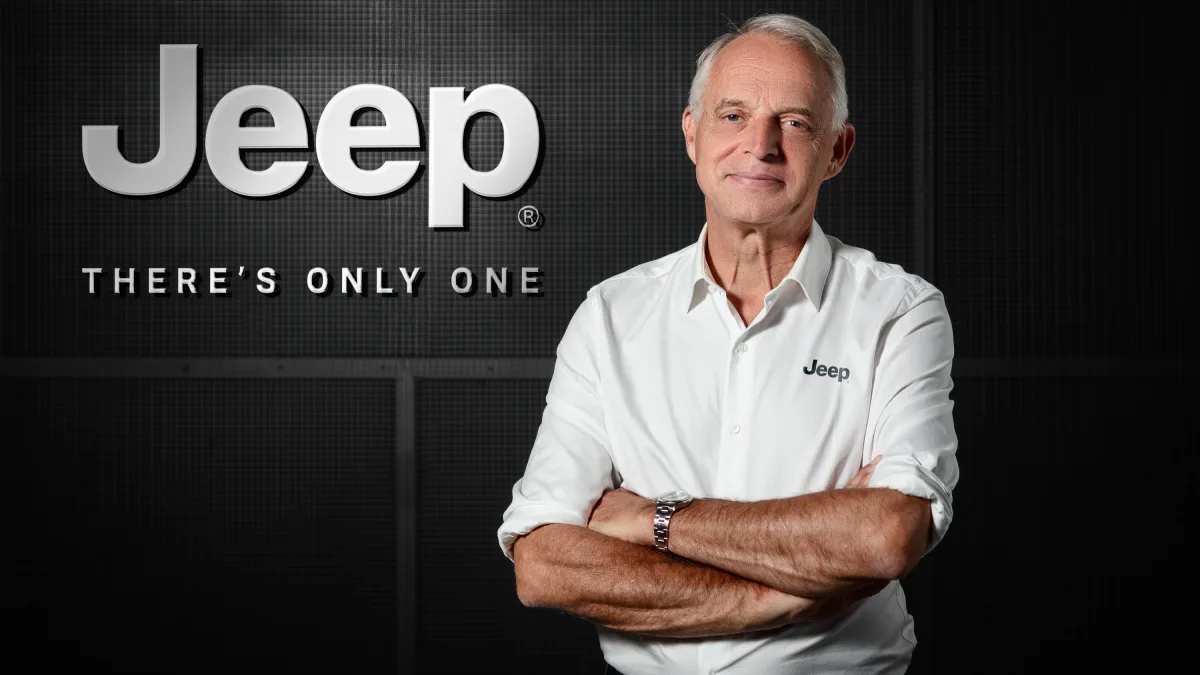 Jeep Renegade. Xavier Peugeot w białej koszuli Jeep stojący przed dużym logo marki