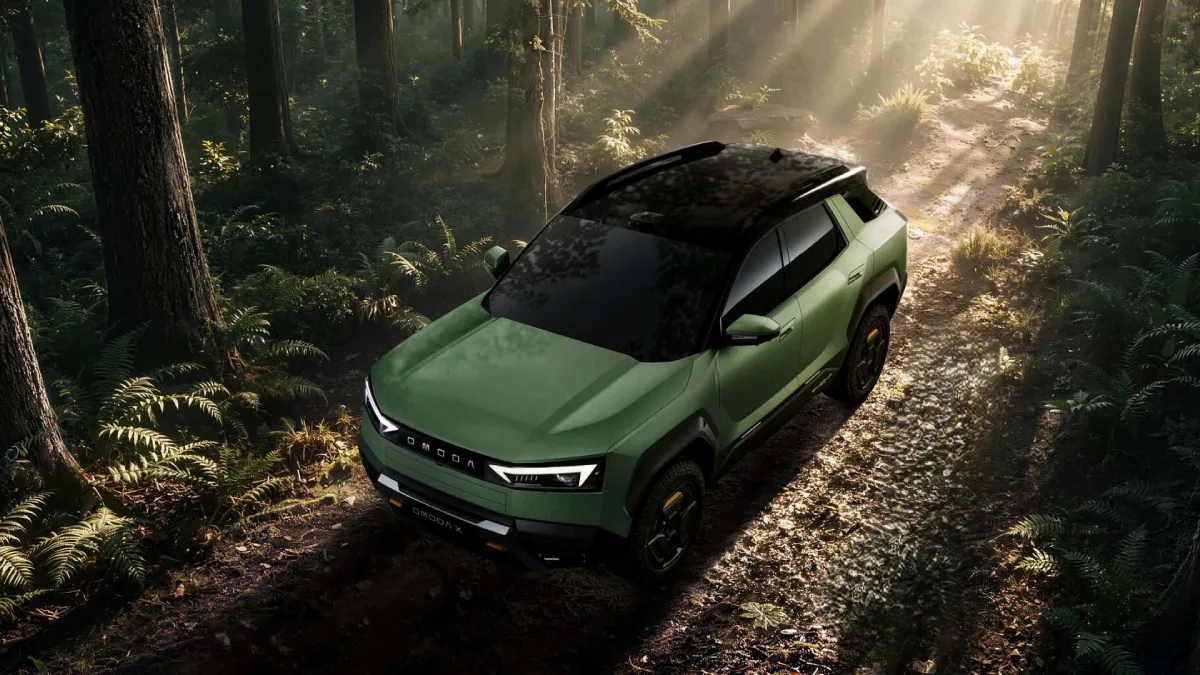 Zielona OMODA X na leśnej drodze, koncepcyjny SUV z oponami o terenowym bieżniku i czarnym dachem