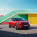 Czerwona Škoda Epiq Sportline 2026 widziana z przodu i boku, z czarnym dachem, obręczami aluminiowymi i reflektorami LED