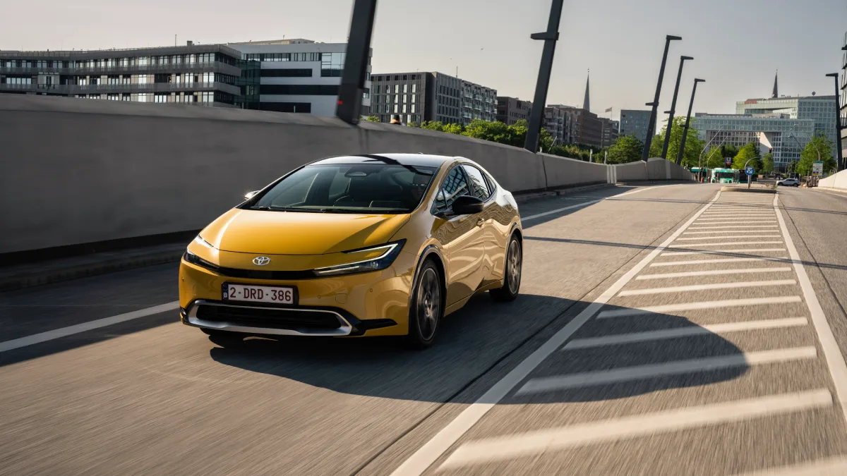 Żółta Toyota Prius Plug-in Hybrid jadąca po miejskiej drodze