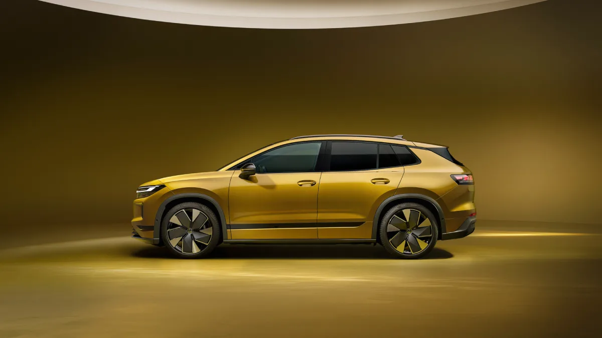 Złoty Volkswagen ID. Tiguan pokazany z boku z czarnym dachem i aerodynamicznymi felgami